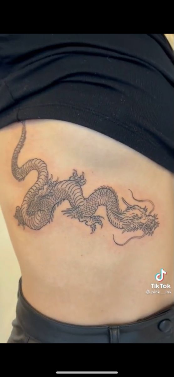 a woman with a dragon tattoo on her stomach