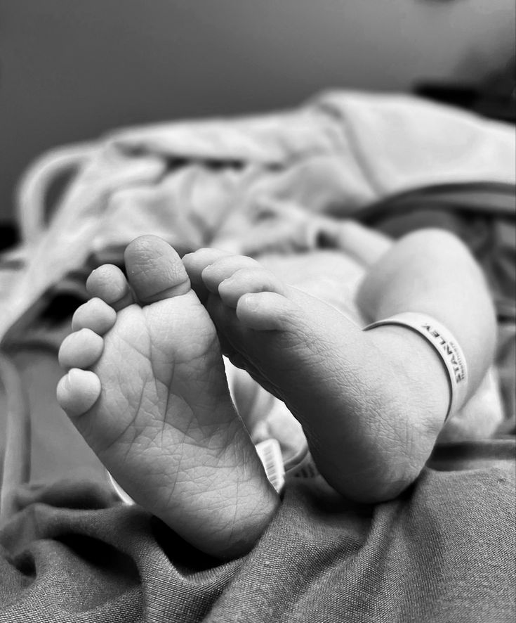 a black and white photo of a baby's feet