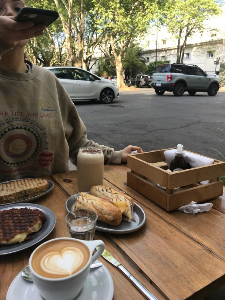 a person sitting at a table with food and drinks