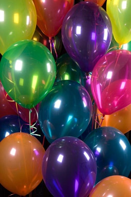 a bunch of balloons that are in the air with string attached to them, all different colors