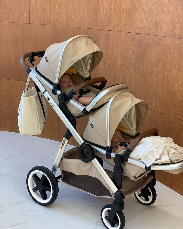 two babies in strollers sitting on a table