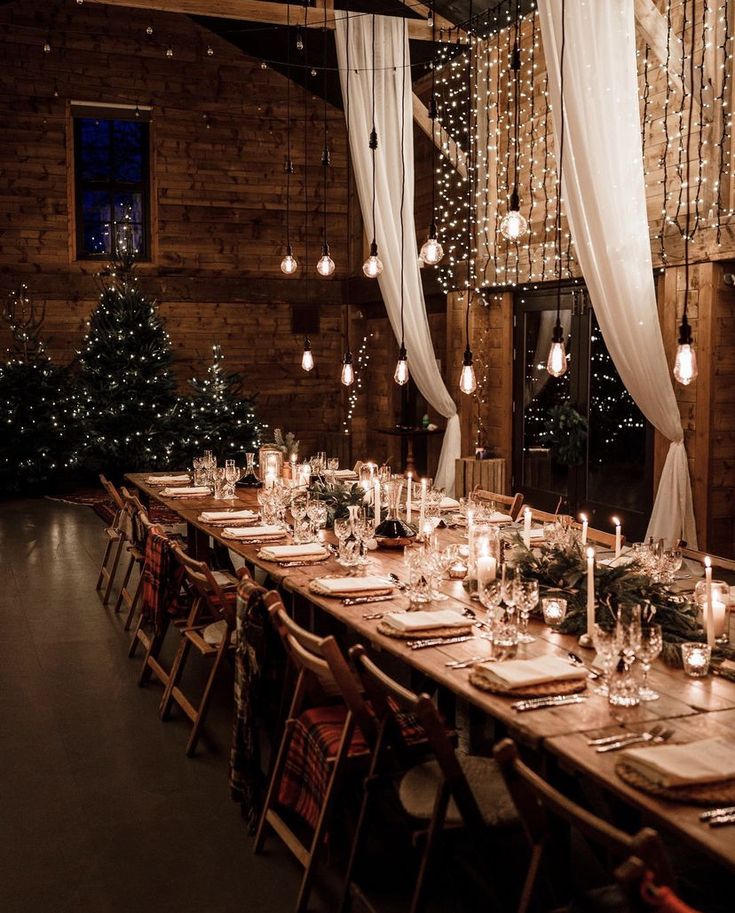 a long table is set up with candles and place settings for an elegant christmas dinner