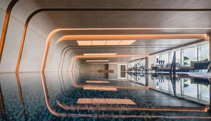 an indoor swimming pool with wooden benches and chairs