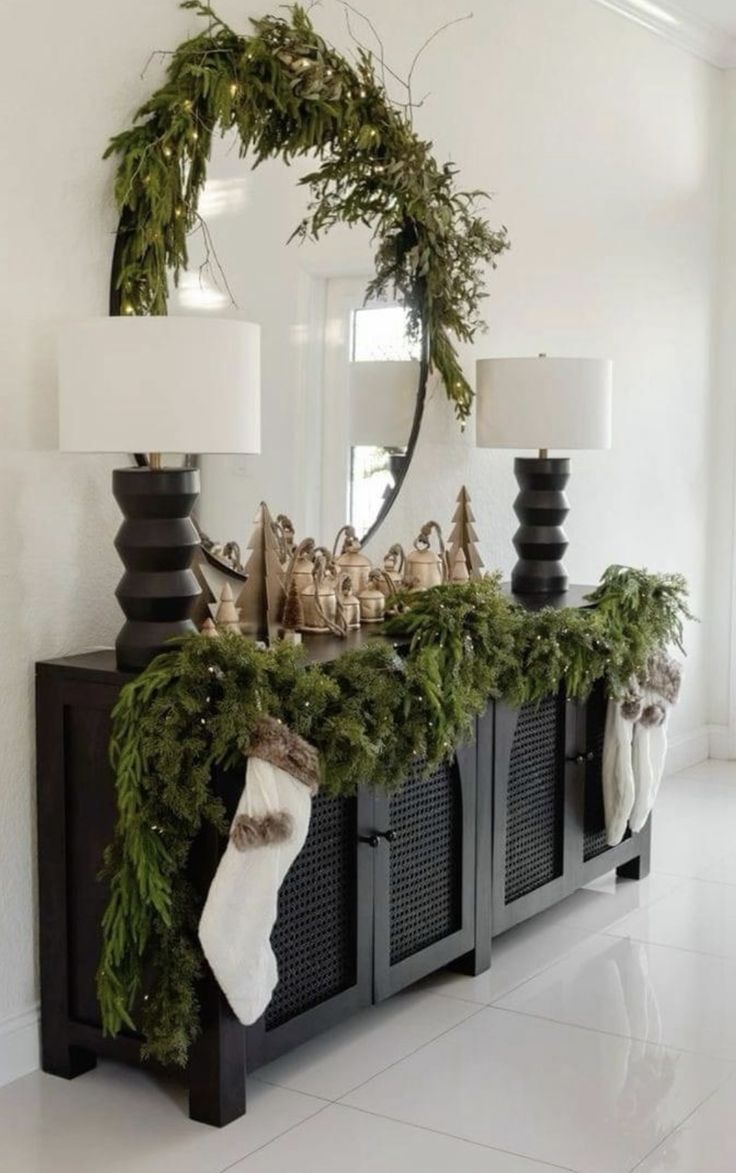 a christmas mantle decorated with greenery, stockings and candles for the mantel or entryway