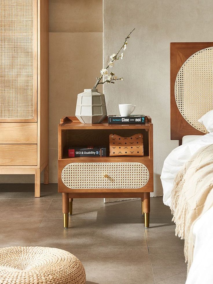 a bed room with a neatly made bed and a night stand on the side table