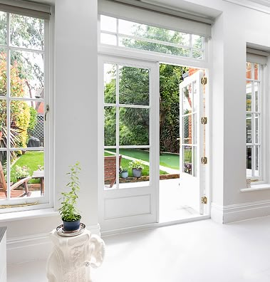 an empty room with white walls and windows