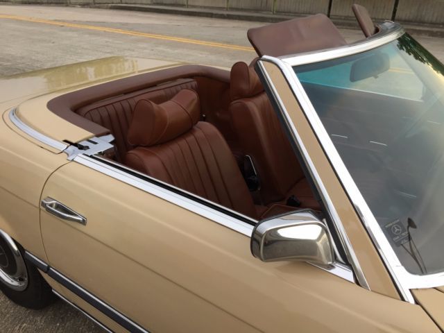 a tan car with brown leather seats is parked on the street