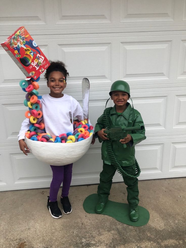 two children dressed up as toy soldiers and one is holding a large bowl of doughnuts