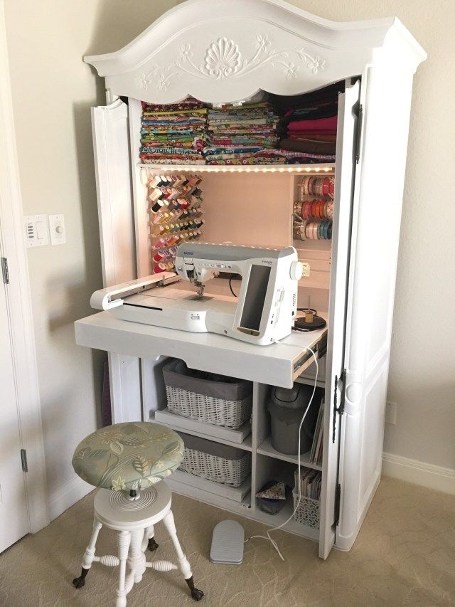 a sewing machine sitting on top of a desk next to a white cabinet filled with fabric