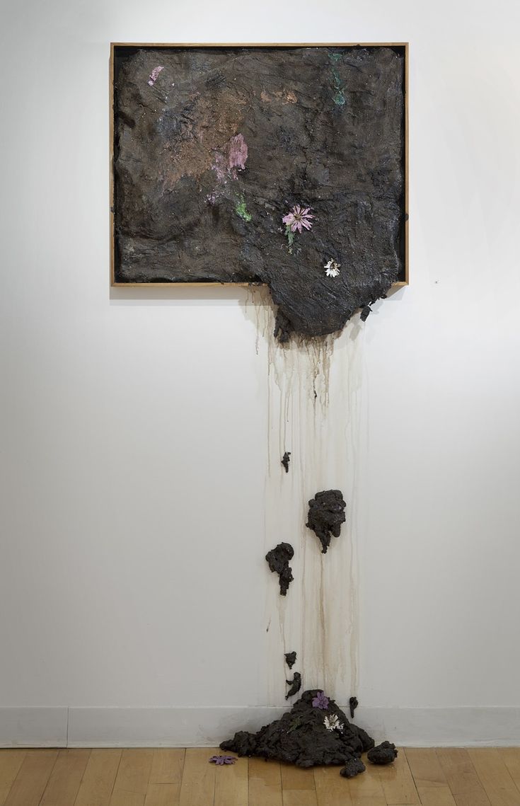 a painting hanging on the wall next to a pile of dirt