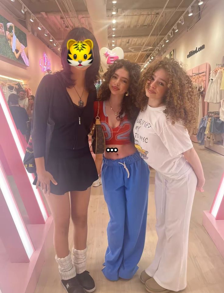 three young women standing next to each other in front of a store display with an image of a tiger on their face