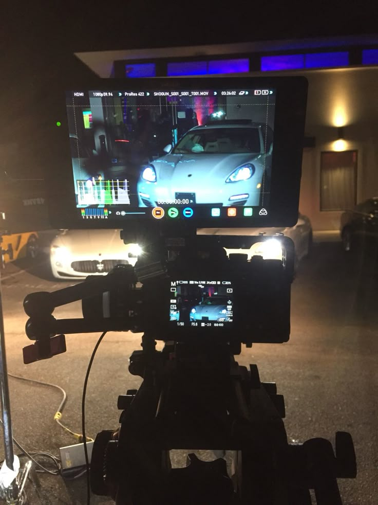 a video camera set up in front of a car with the image of a sports car on it's screen