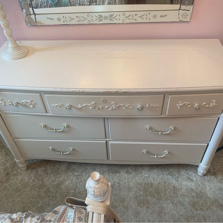 a white dresser and mirror in a room