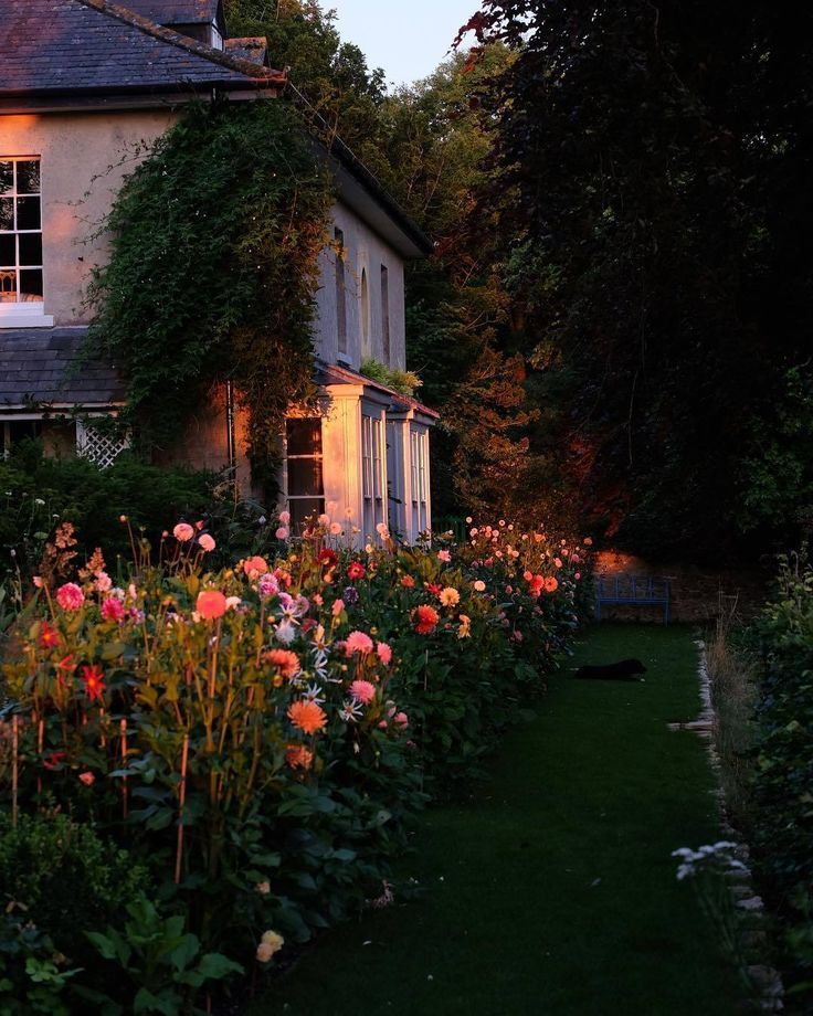 the house is surrounded by flowers and trees