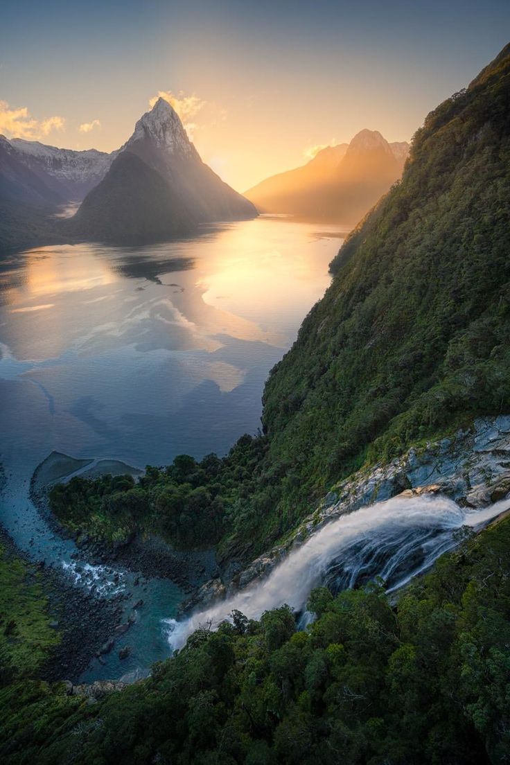 an aerial view of a river and mountains at sunset