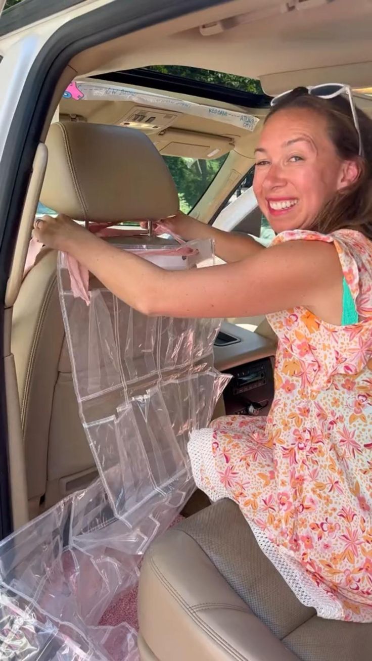 a woman sitting in the back seat of a car with plastic bags on it's sides