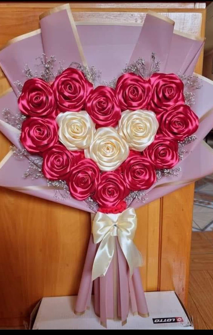 a bouquet of roses in the shape of a heart is displayed on a card board