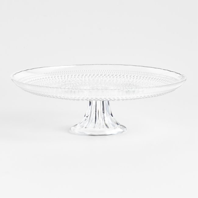 a clear glass cake plate sitting on top of a table