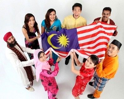 a group of people standing next to each other holding an american and malaysian flag