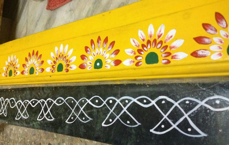 an artisticly painted yellow and black bench on the side of a building in india