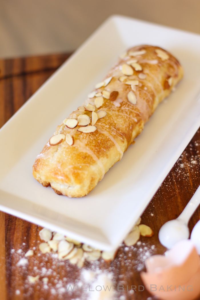 a white plate topped with a pastry on top of a wooden table