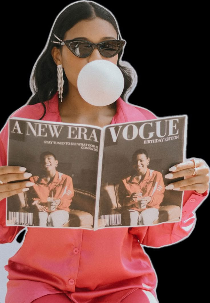 a woman in pink is blowing a bubble while holding a newspaper and chewing on her nose