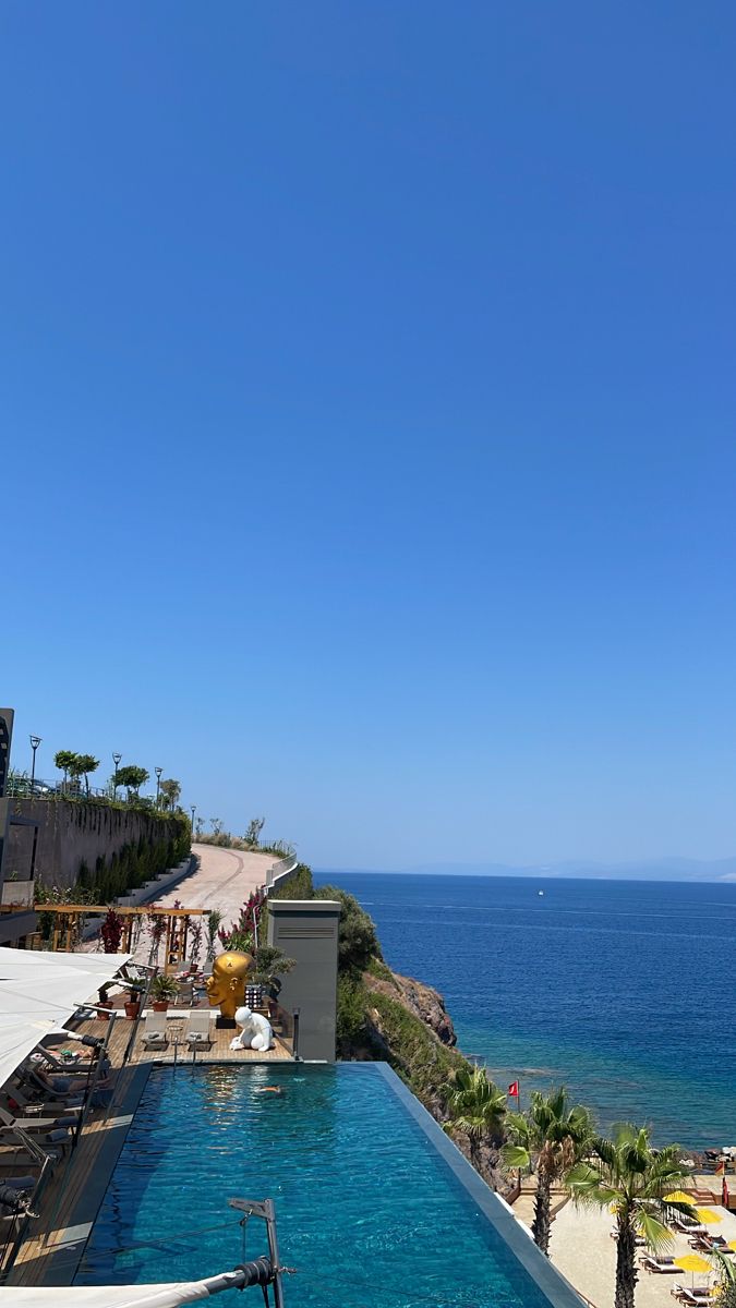 an empty swimming pool next to the ocean