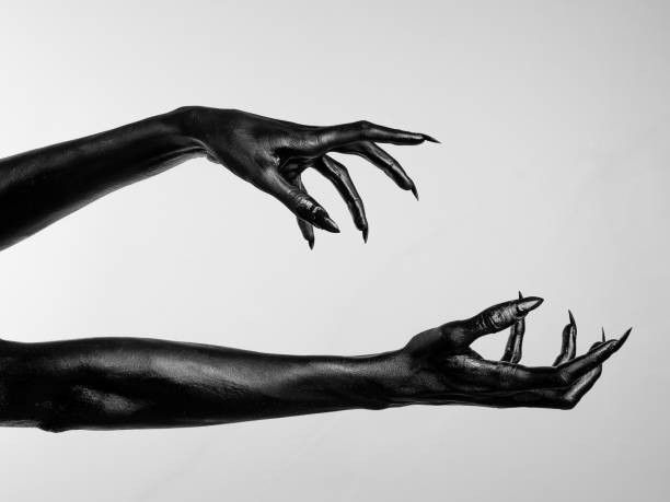 black and white photograph of two hands reaching for each other with their claws spread out