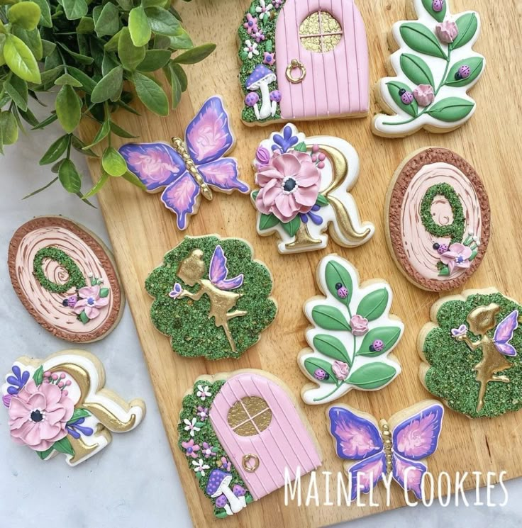 decorated cookies are displayed on a cutting board