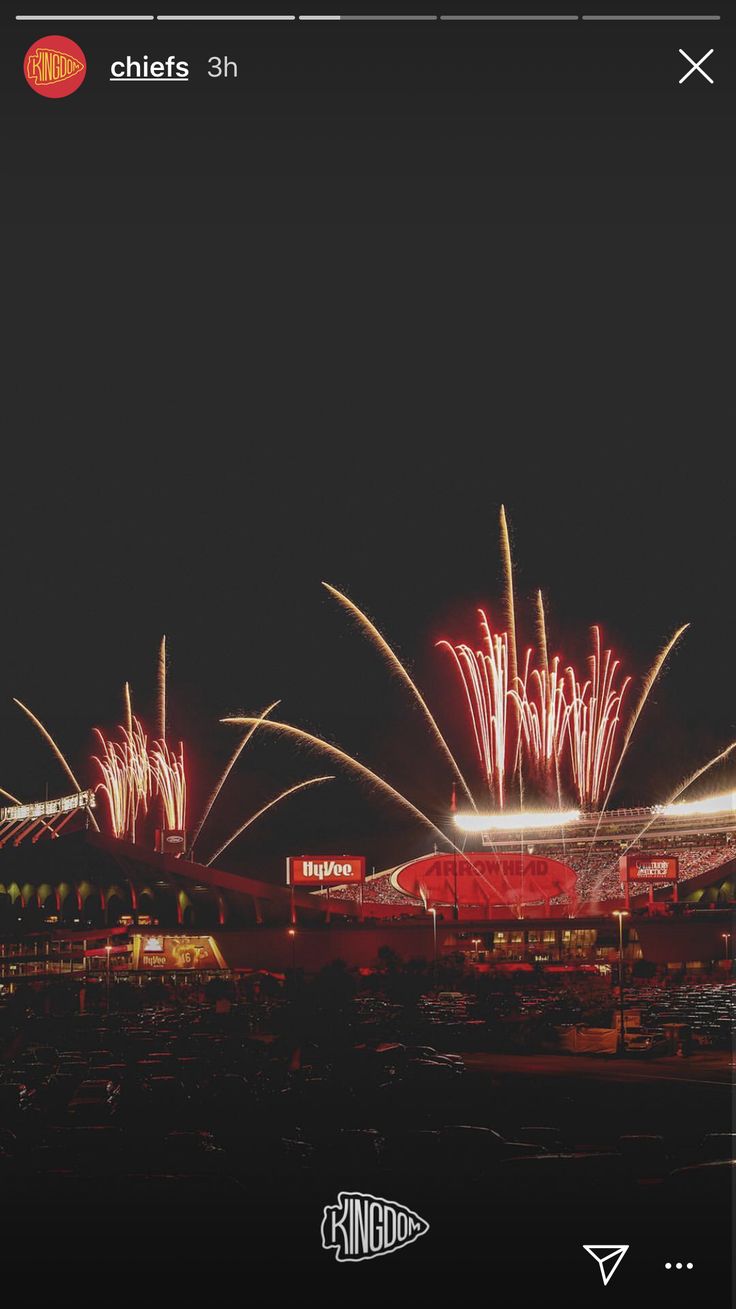 fireworks are lit up in the night sky above a stadium with lights on it's roof