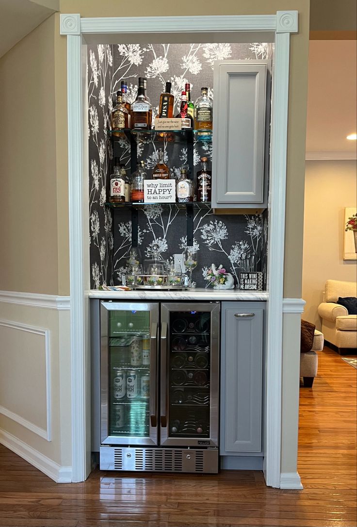 an open cabinet in the corner of a room filled with liquor bottles and glasses on top of it