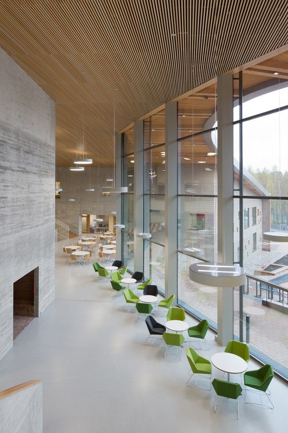 a long row of green chairs sitting next to each other in front of a window