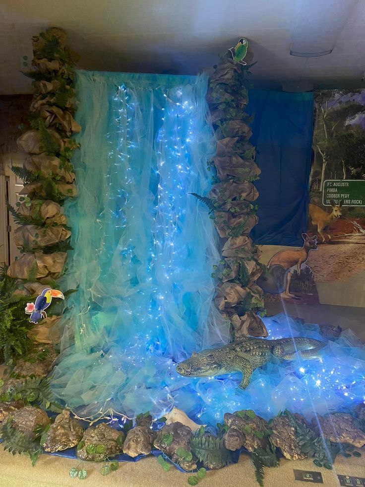 an aquarium display with blue lights and water flowing down it's sides, including a large waterfall