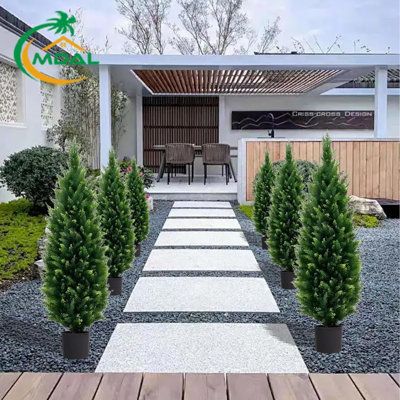 an outdoor area with wooden floors and plants in the foreground, surrounded by graveled walkway