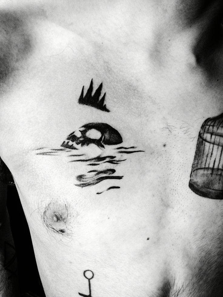 a man's chest with an anchor and birdcage on it