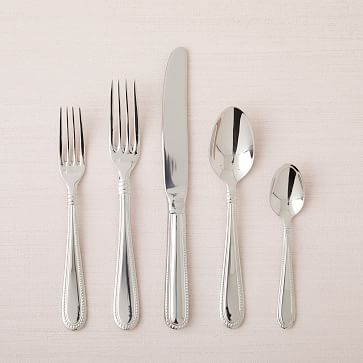 five silverware pieces on a white surface