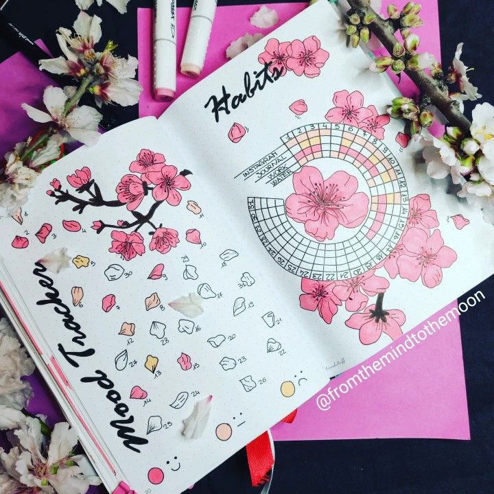 an open notebook with stickers on it next to some flowers and other items that include pens