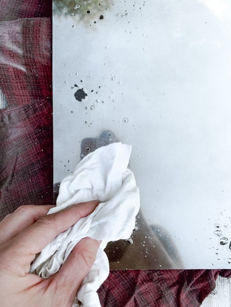 a person wiping up some white paper on a piece of cloth with a rag in front of them