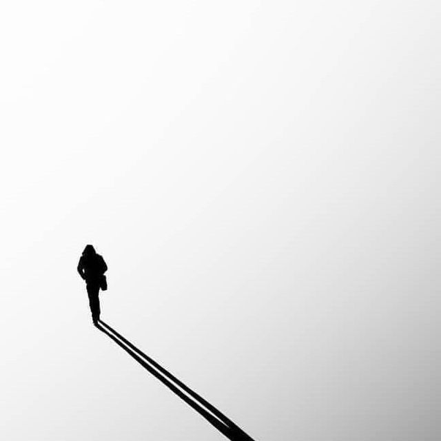 a person standing on top of a metal pole with an umbrella in the sky behind them