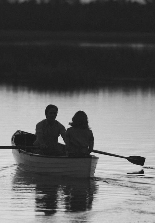 two people in a small boat on the water