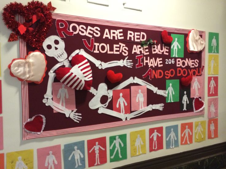 a bulletin board is decorated with skeletons and red heart shaped paper cutouts for valentine's day