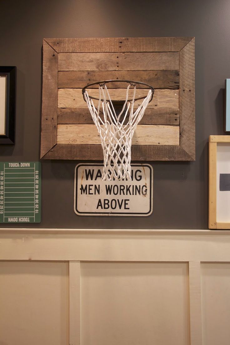 a man's basketball hoop mounted on the wall above a sign that reads, warning men working above