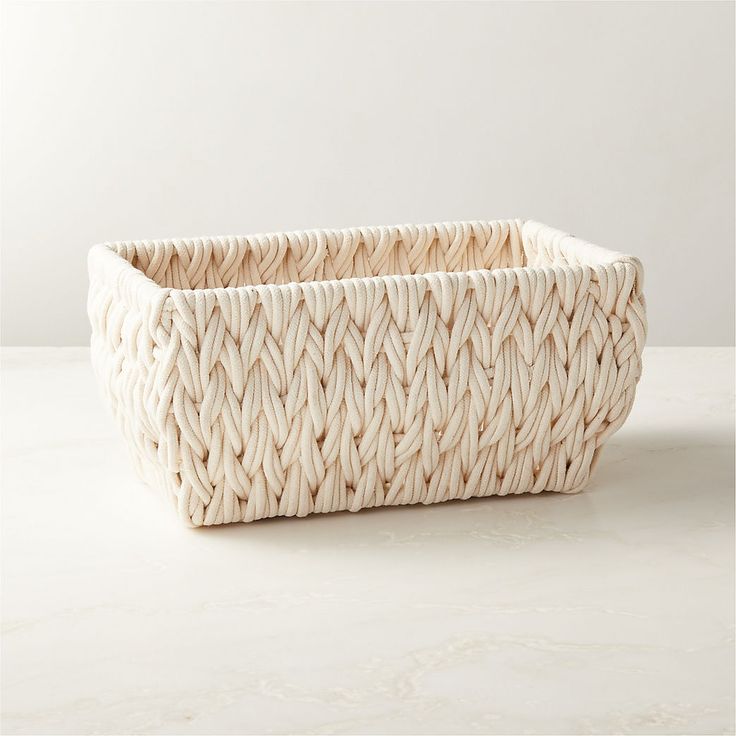 a white woven basket sitting on top of a table