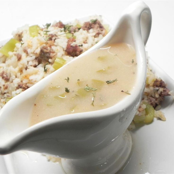 a white gravy dish with rice and vegetables