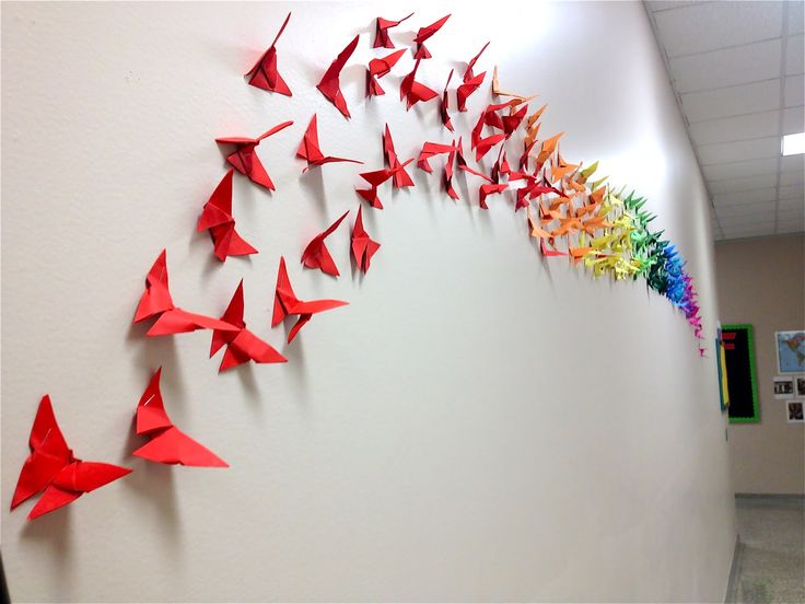 there are many red origami birds on the wall