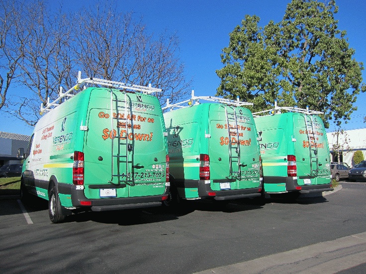 three green van parked next to each other in a parking lot