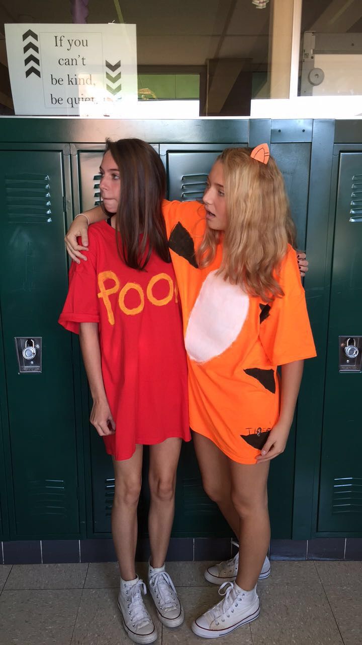 two girls in costumes standing next to lockers with their arms around each other's backs