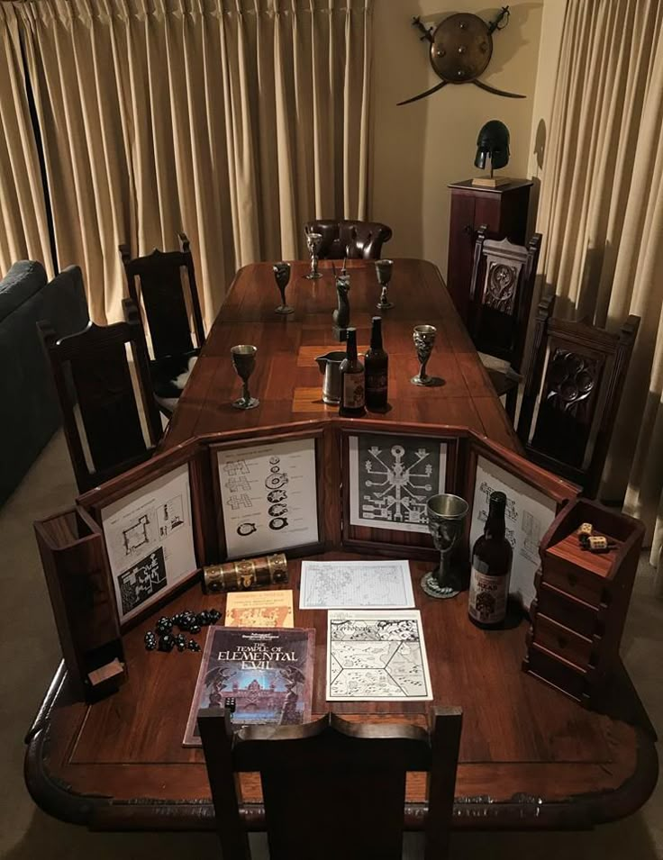 a wooden table topped with lots of framed pictures and wine glasses on top of it