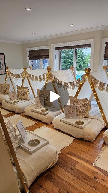 a room filled with lots of pillows on top of a hard wood floor next to windows