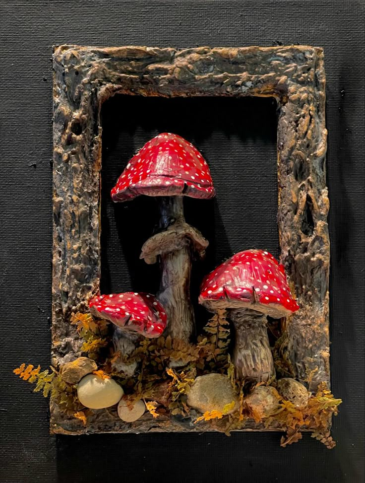 two red mushrooms are in a frame on the wall